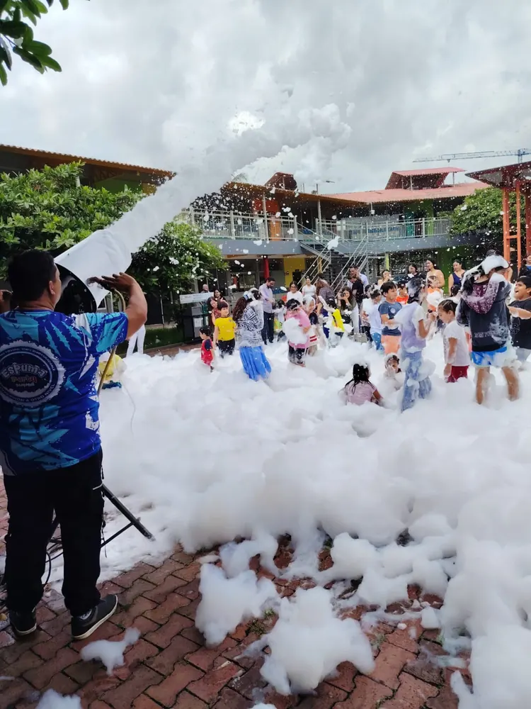 Operador lanzando espuma con el cañón sobre niños en una fiesta escolar en Guayaquil