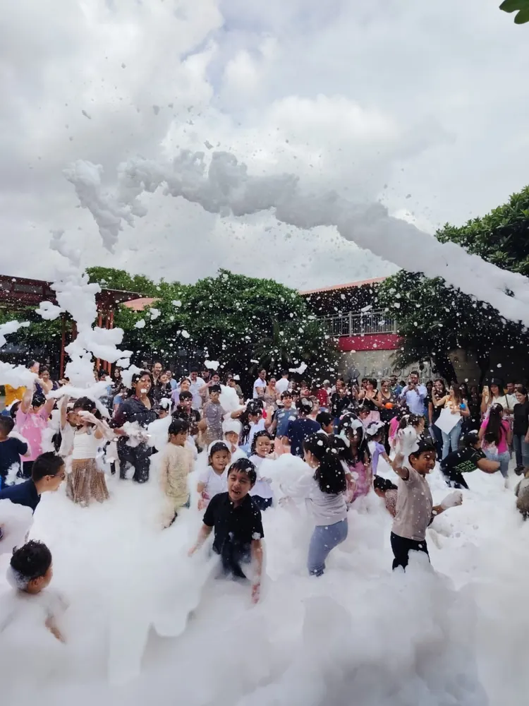 Familias y niños jugando en una fiesta de espuma al aire libre en Guayaquil