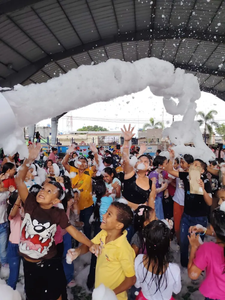 Cañón de espuma cubriendo a niños felices en un evento comunitario